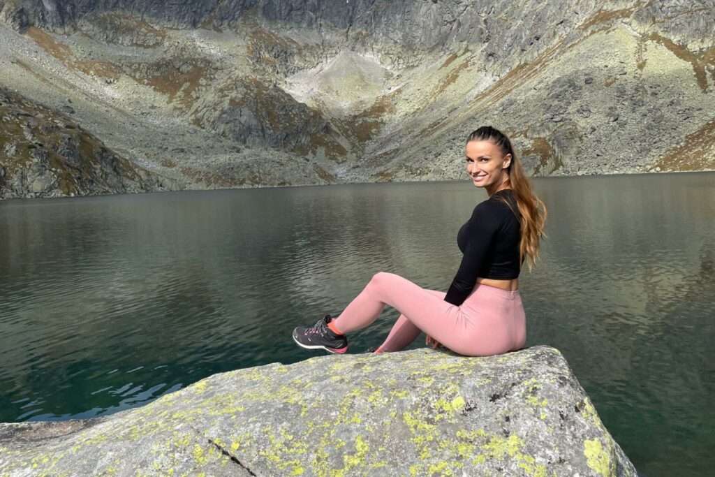 Jana Húšťavová sedí na skale pri jazere.